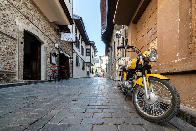 Przytulne uliczki kaleichi w antalyi motocykl zaparkowany na pustej, przytulnej ulicy. cisza i spokój w historycznym centrum Antalyi w Turcji. podróż i turystyka.