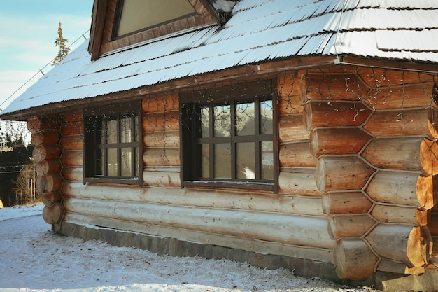 Przytulny drewniany dom ze śniegiem w zimowy dzień