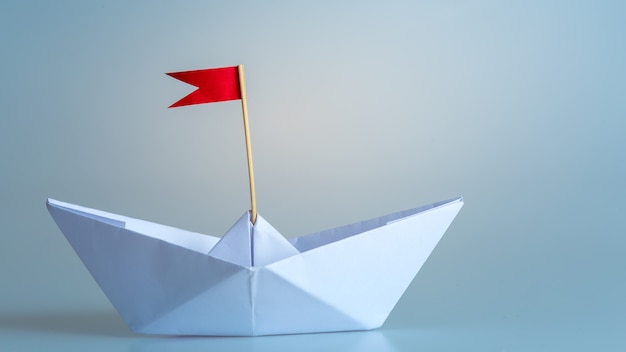 Przywódctwo pojęcie używać papierowego statek z czerwoną flaga na błękitnym tle