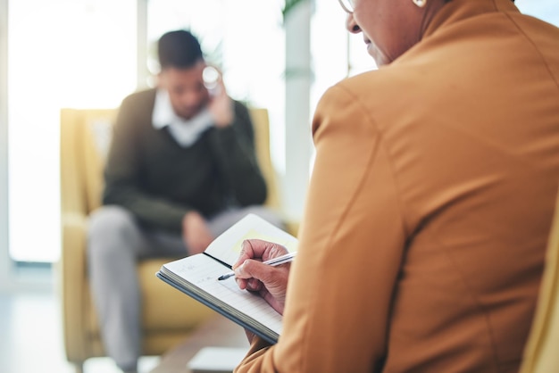 Psycholog pisze stres mężczyzny i sofę z terapią kobiety i słucha sposobu myślenia lub opieki w zakresie zdrowia psychicznego Psychiatra pacjent z depresją i sfrustrowany w notatniku kliniki i pomoc w przypadku lęku