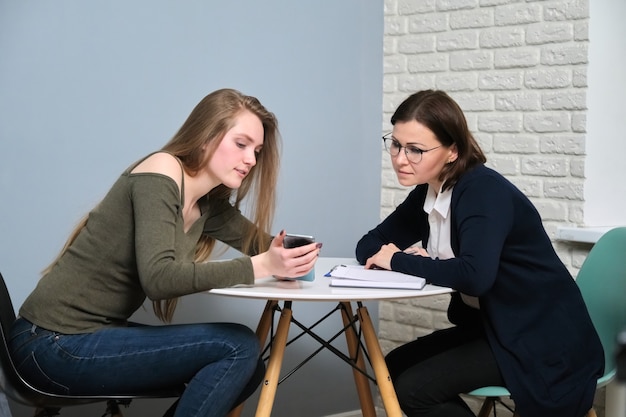 Psychoterapia, sesja psychoterapii u profesjonalnego psychologa lekarza w gabinecie. Pacjentka młoda kobieta rozmawia ze specjalistą, zdrowiem psychicznym, problemami młodzieży
