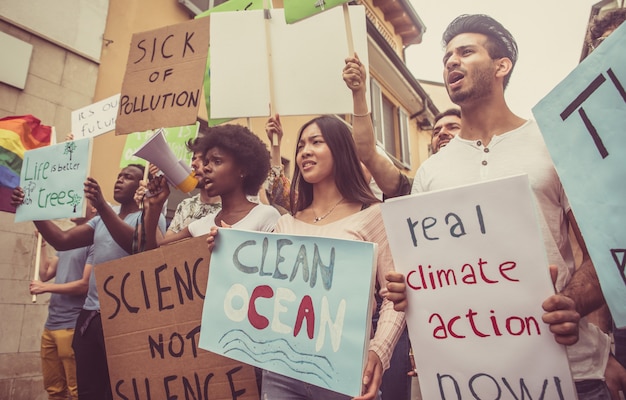 Publiczna Demonstracja Na Ulicy Przeciwko Globalnemu Ociepleniu I Zanieczyszczeniu. Grupa Wieloetnicznych Ludzi Protestujących Przeciwko Zmianom Klimatu I Problemom Z Tworzywami Sztucznymi W Oceanach