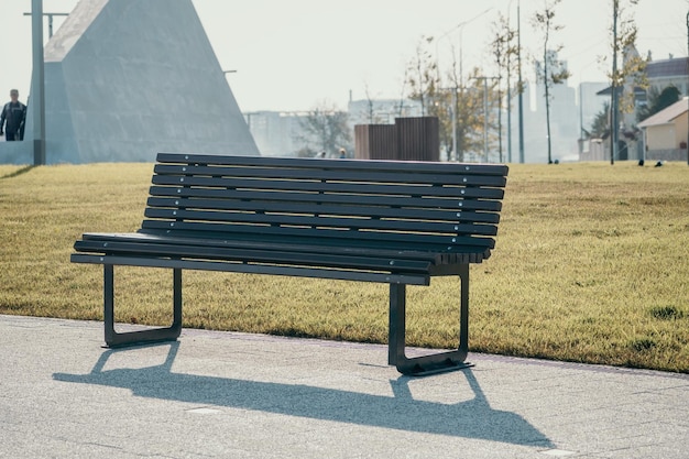 Publiczny park nad morzem z drewnianą ławką w wiosenny wieczór Brak ludzi