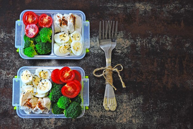 Zdjęcie pudełka na lunch ze zdrowym posiłkiem. przekąska fitness w pudełku na lunch. brokuły, jaja przepiórcze, pierś kurczaka i pomidory koktajlowe.