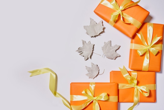 Pudełka na prezenty i jesienne liście na białym tle kreatywny układ jesiennych liści i pomarańczowy prezent ...