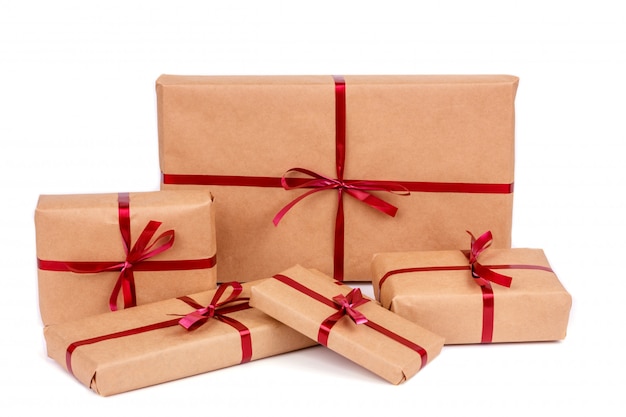 Zdjęcie pudełka na prezenty w ręcznie pakowanym papierze do pakowania z czerwonymi wstążkami