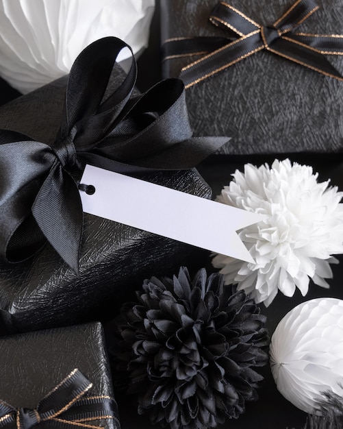 Zdjęcie pudełka na prezenty z czarno-białymi papierowymi kwiatami i dekoracjami pozioma zawieszka na prezent makieta