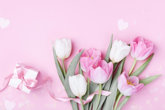 Pudełko na prezent i piękne wiosenne kwiaty tulipanów na pastelowym różowym tle Baner na Dzień Kobiet Matki