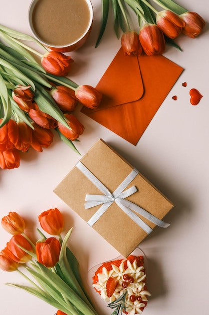 Pudełko na prezent z łukiem, bukietem tulipanów i kopertą na festiwalowy tło