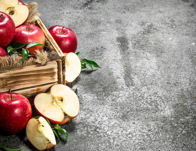 Zdjęcie pudełko z dojrzałymi czerwonymi jabłkami. na rustykalnym tle.