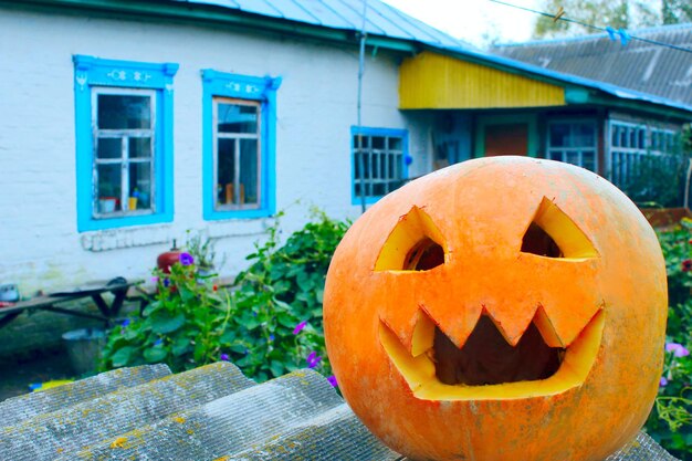 Pumpking jest gotowy na Halloween na tle wiejskiego domu