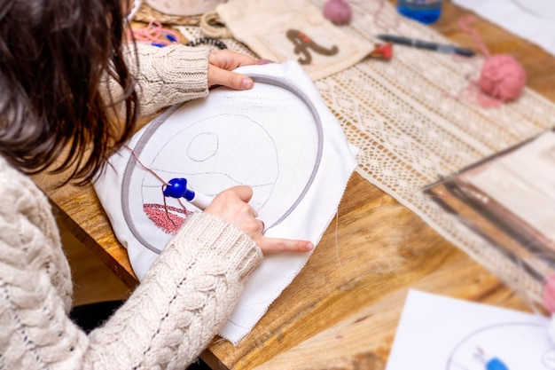 Punch Needle Workshop Zbliżenie kobiecych rąk wykonujących szkic projektu