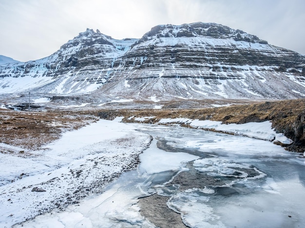 Punkt widokowy góry Kirkjufell i wodospadu Kirkjufellfoss na Islandii zamarzająca woda zamienia się w lód