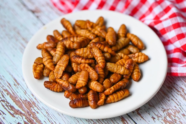 Zdjęcie pupa na białym tle fry robaki jedwabne smażone pupa dla żywności robak