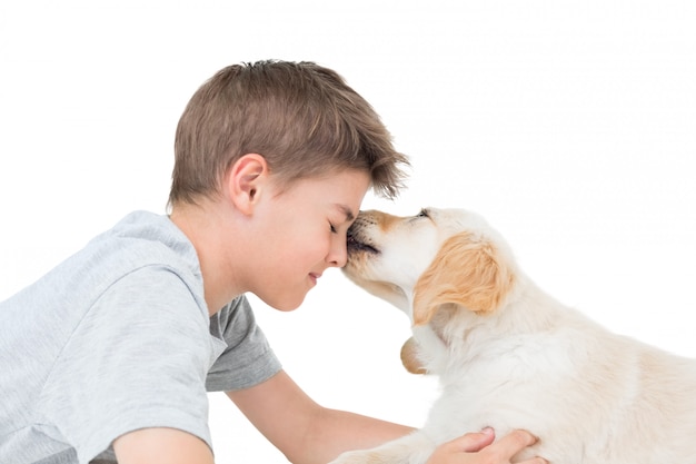 Puppy lizanie chłopca na białym tle