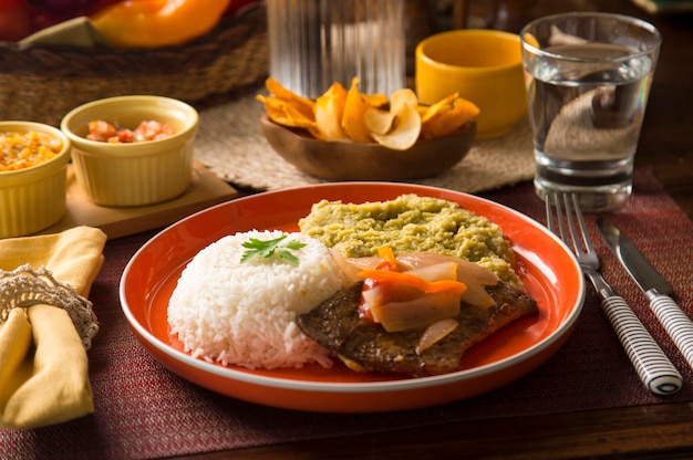 Puree z białego ryżu z groszkiem i smażoną wątróbką Peru peruwiańskie jedzenie komfortowe mise en place drewniany stół