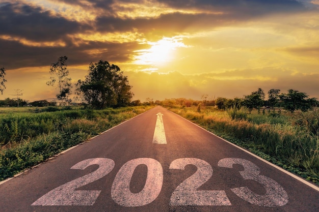 Pusta asfaltowa droga i koncepcja Nowego Roku 2023 Jazda po pustej drodze do Goals 2023 o zachodzie słońca
