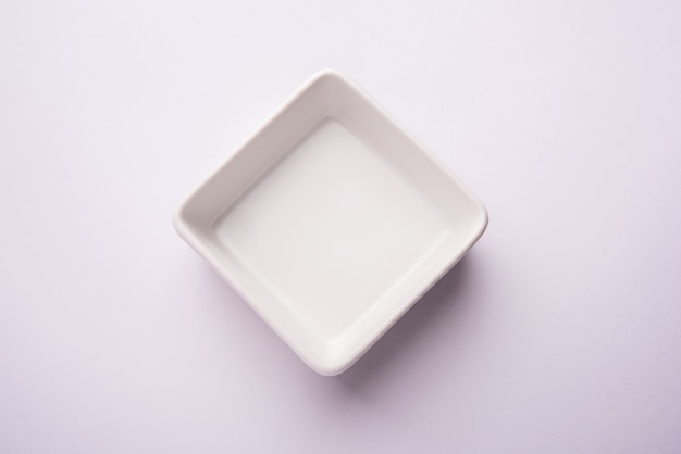 Pusta biała ceramiczna miska do serwowania, izolowana na białej lub szarej powierzchni