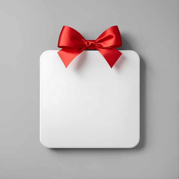 Pusta biała kwadratowa karta z czerwoną wstążką prezentową na szarym tle