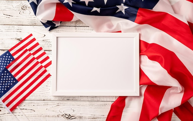 Pusta biała ramka na zdjęcia do makiety na drewnianym tle amerykańskiej flagi narodowej