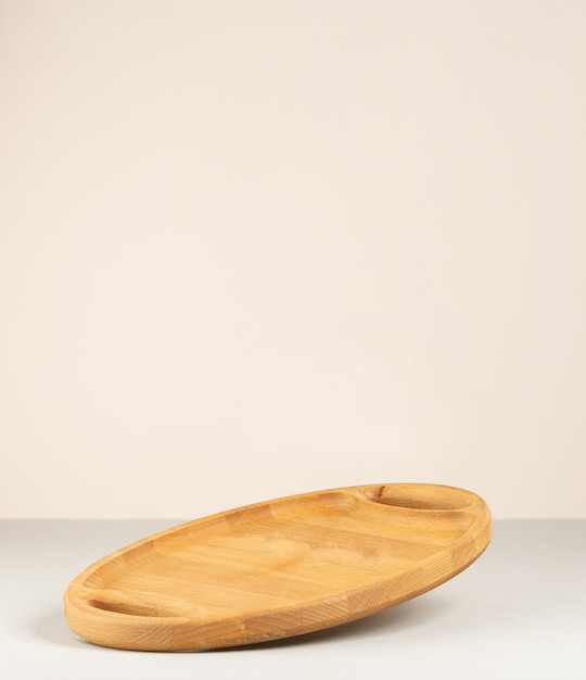 Pusta brązowa drewniana deska kuchenna na szarym tle papieru, naczynia