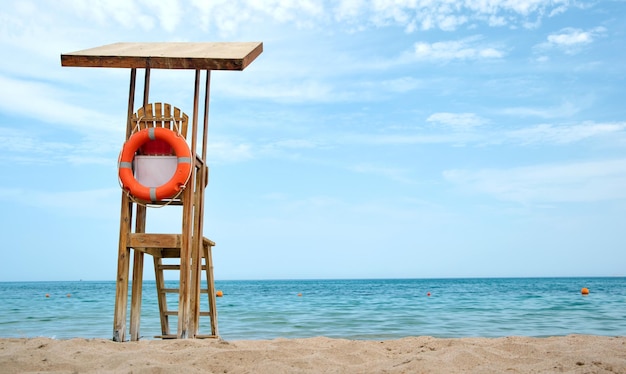 Zdjęcie pusta drewniana stacja ratownika na piaszczystej plaży nad brzegiem oceanu w lecie