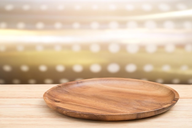 Pusta drewniana taca na perspektywicznym drewnianym stole na górze nad rozmytym tłem Może służyć do makiety do wyświetlania produktów montażowych lub układu projektowego