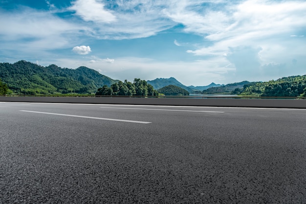 Zdjęcie pusta droga asfaltowa i naturalny krajobraz pod błękitnym niebem