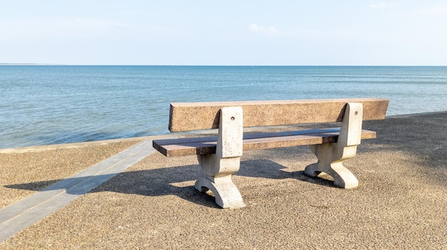 Pusta ławka drewniany cement na wybrzeżu plaży przed oceanem