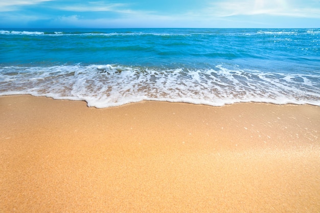 Pusta plaża na morzu lub oceanie z delikatną falą fal i czystym żółtym piaskiem Letnia koncepcja tła