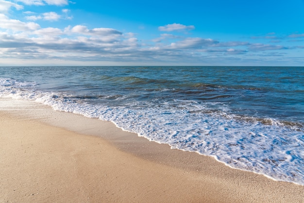 Pusta plaża z żółtym piaskiem i błękitnymi falami, kwarantanna w ośrodku