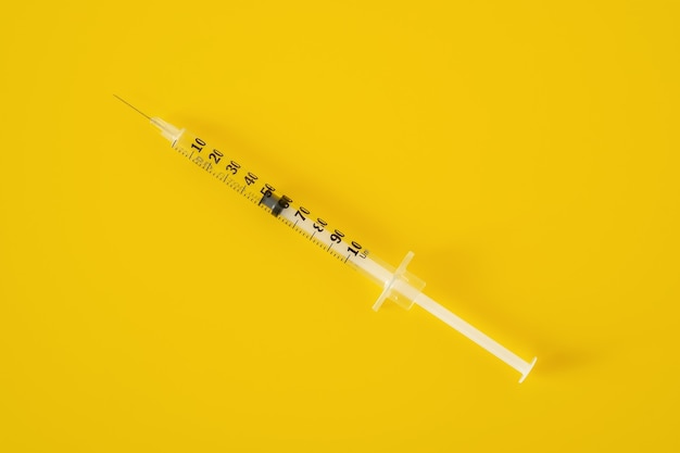 Pusta strzykawka insulinowa na żółtym tle