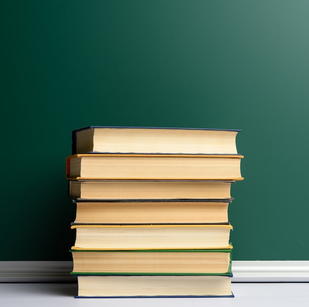Pusta tablica szkolna zielona kreda i stos książek, powrót do szkoły, kopia przestrzeń