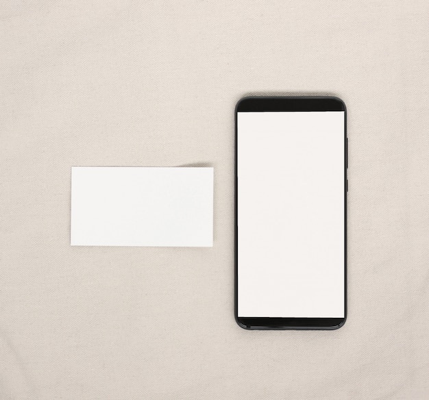 Pusta wizytówka i telefon komórkowy z białym ekranem