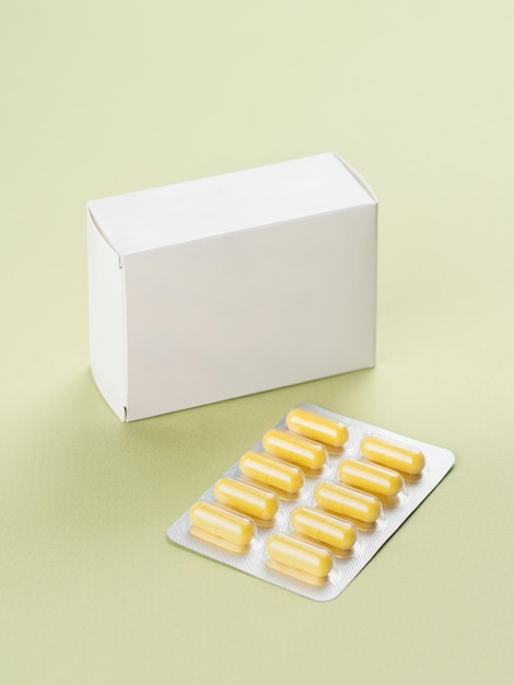 Puste białe opakowanie produktu lekarstwo Pudełko MockupxAobok pudełka znajduje się blister z widokiem z góry na witaminę Miejsce na logo i tekst