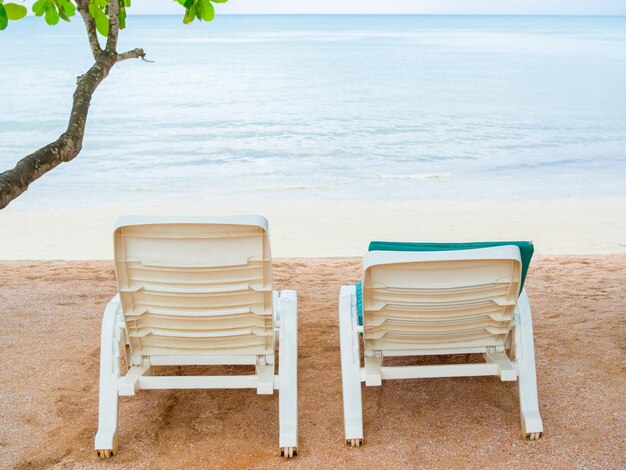 Zdjęcie puste białe plastikowe leżaki na piaszczystej plaży