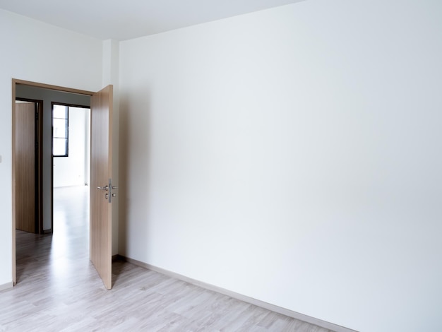 Puste białe tło ściany w pustym pokoju w pobliżu drewnianych otwartych drzwi z kopią Białe tło ściany w nowym domu