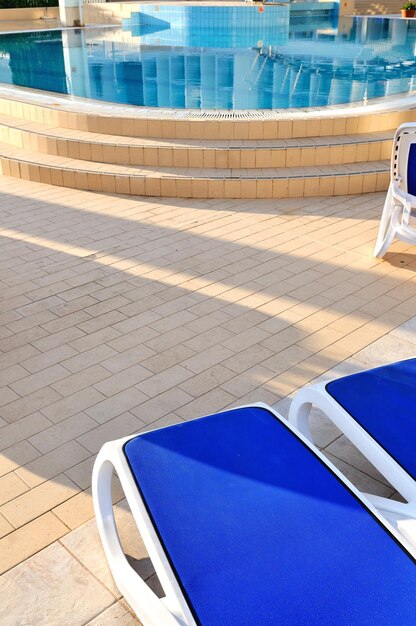 Zdjęcie puste krzesła przy basenie hotelu.