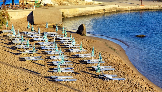 Puste leżaki na piaszczystej plaży w reosrt Panormos na wyspie Kreta Grecja