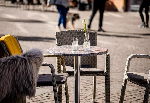 Puste stoliki na zewnątrz między godzinami lunchu wzdłuż brukowanej uliczki w europejskim mieście, weranda i kawiarnia