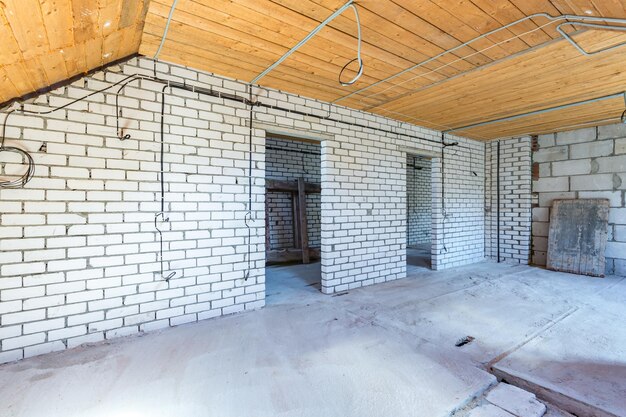 Puste wnętrze w domu bez naprawy na drewnianej podłodze mansardowej i ceglanym murze