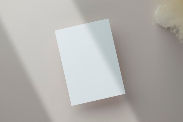 Puste zaproszenie na kartkę z życzeniami makieta 5x7 na kopercie z suchymi kwiatami i wstążką na tle papieru płaskie świeckich makieta