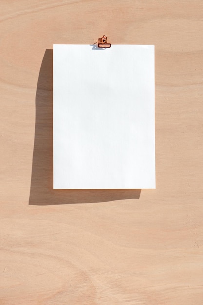Pusty biały kolor papieru na białym tle na drewnianym tle.