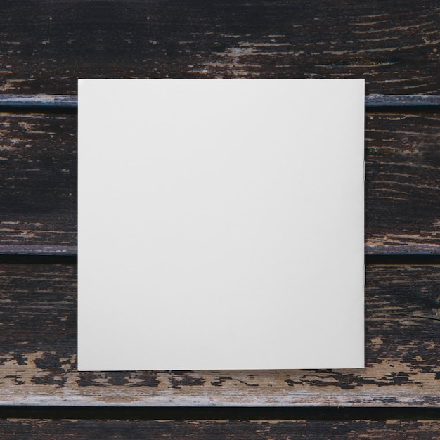 Zdjęcie pusty biały papier izolowany na drewnianym tle