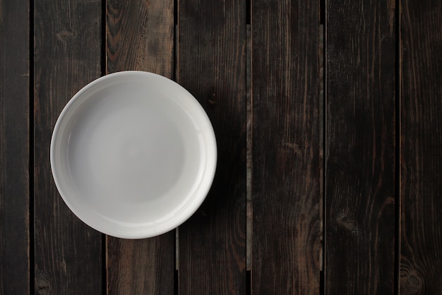 Pusty biały talerz na drewnianym stole na poddaszu. Wysokiej jakości zdjęcie