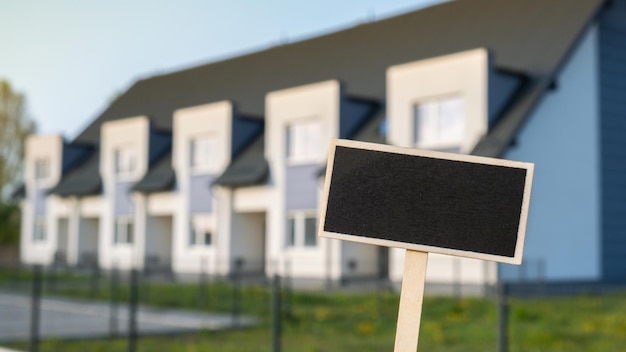 Pusty czarny billboard przeciwko mieszkaniu dom rodzinny Pusty szablon makieta Etykieta tablica w Townhome Kopiuj transparent miejsca na tekst Dom wielorodzinny Koncepcja cena wynajmu domu kupno domu