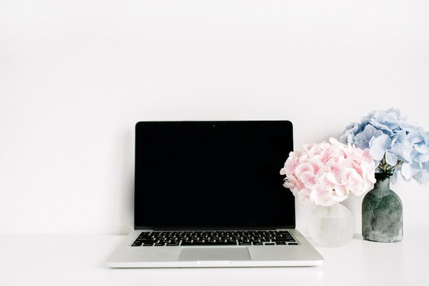 Pusty Ekran Laptopa I Różowe I Niebieskie Bukiety Kwiatów Hortensji Na Białej Powierzchni