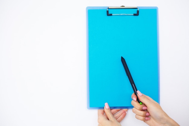 Pusty folder z niebieskim papierem. Ręka, która trzyma folder i długopis na białym tle.