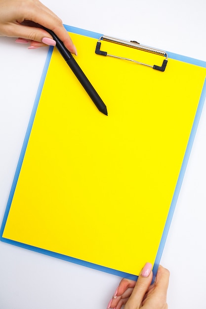 Pusty Folder Z żółtym Papierem, Ręka, Która Trzyma Folder I Uchwyt Na Białym Tle