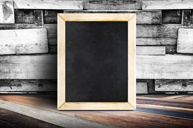 Pusty menu blackboard opiera przy deski drewna ścianą i przekątną drewnianą podłoga